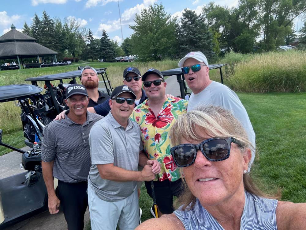Kim Schmidt with football alums on the course.